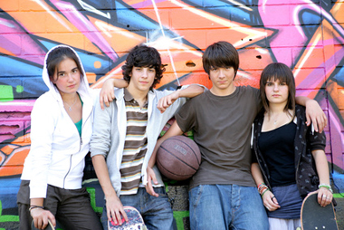 Adolescents devant un mur de graffitis