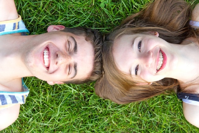 Ados amoureux couchés dans l'herbe