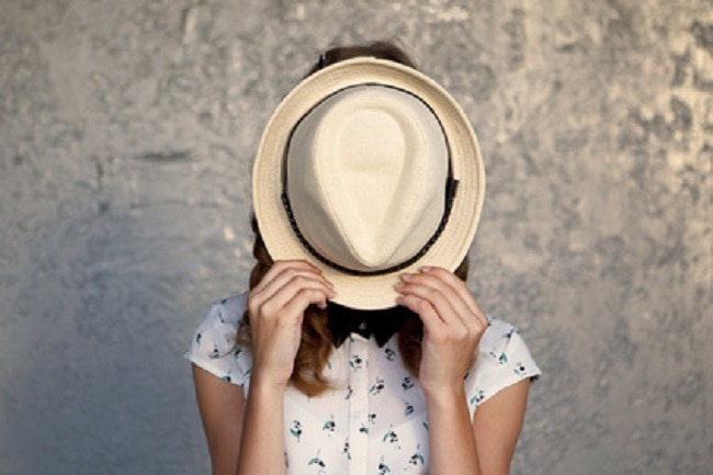 Adolescentes visage caché derrière son chapeau