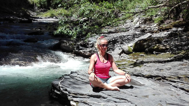 Pause yoga en bord de torrent au cours d'une rando bien-être