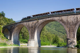 Train de l'Ardèche sur pont de pierre dans les Gorges du Doux