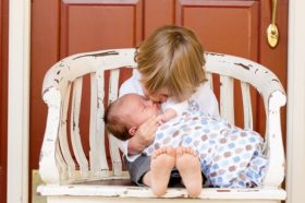 Petit garçon sur un banc embrassant un bébé