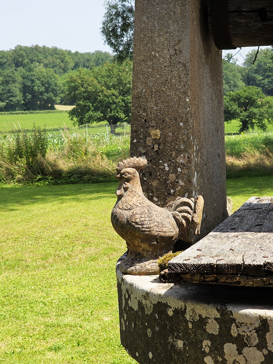 statue en pierre d'un poulet emblème de la Bresse