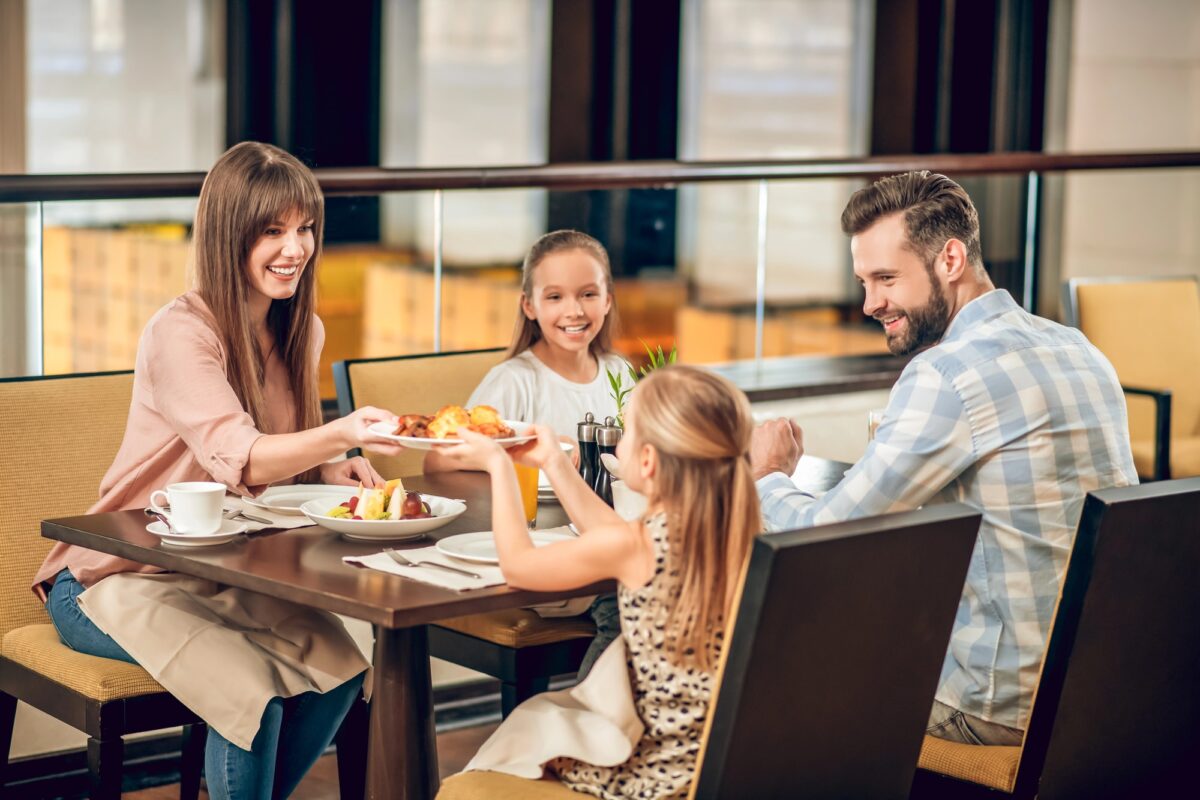 Famille avec enfants attablée au restaurant, au cœur du débat sur les espaces no kids