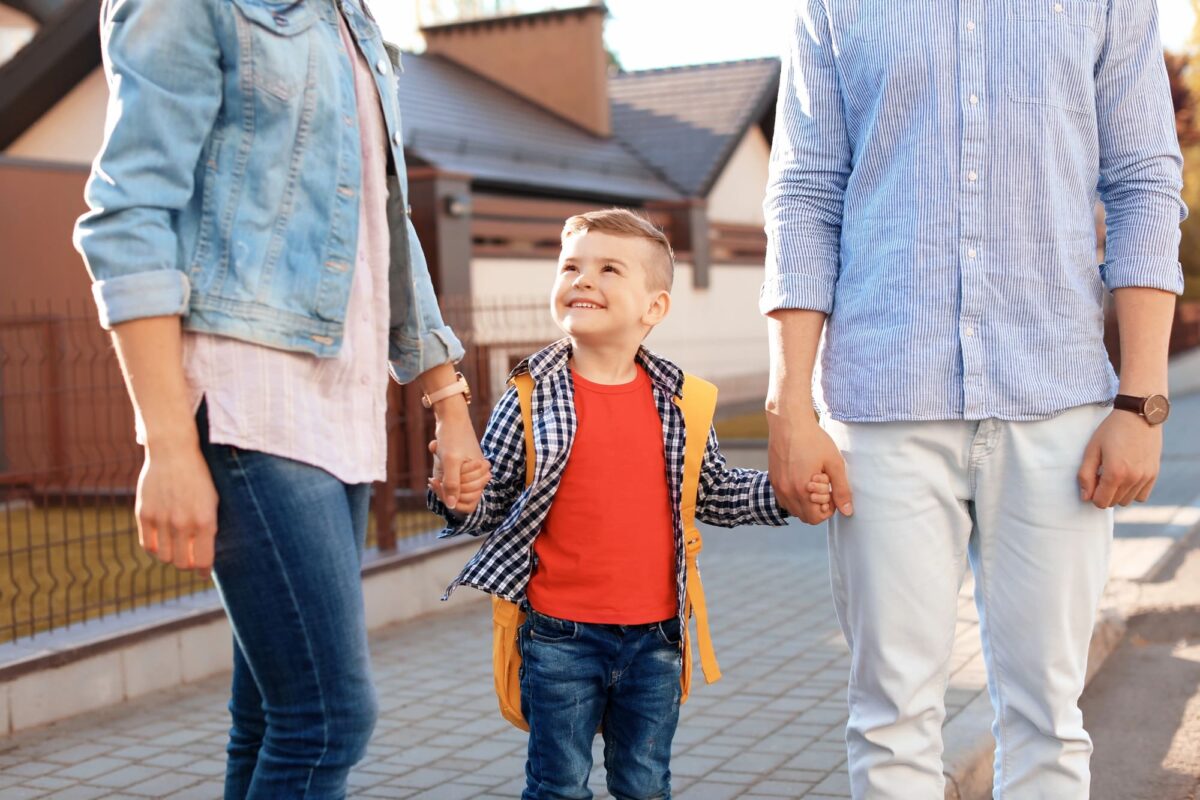 enfant souriant entre ses deux parents séparés