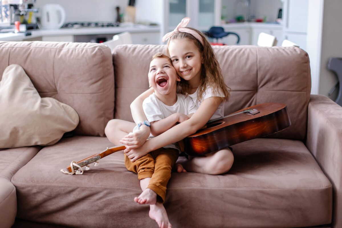 petite fille joue de la guitare avec son frère handicapé