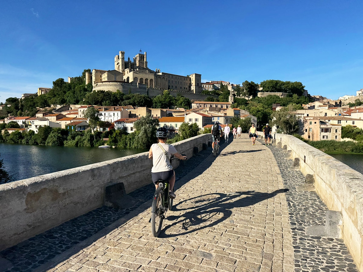 à vélo sur le pont vieux de béziers avec vue sur la cathédrale