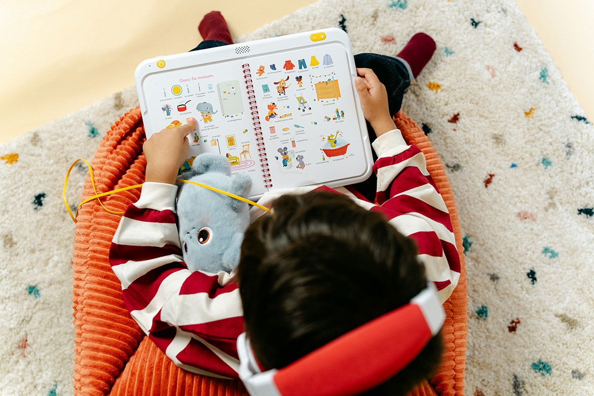enfant en train de lire un livre interactif sur hopiplay