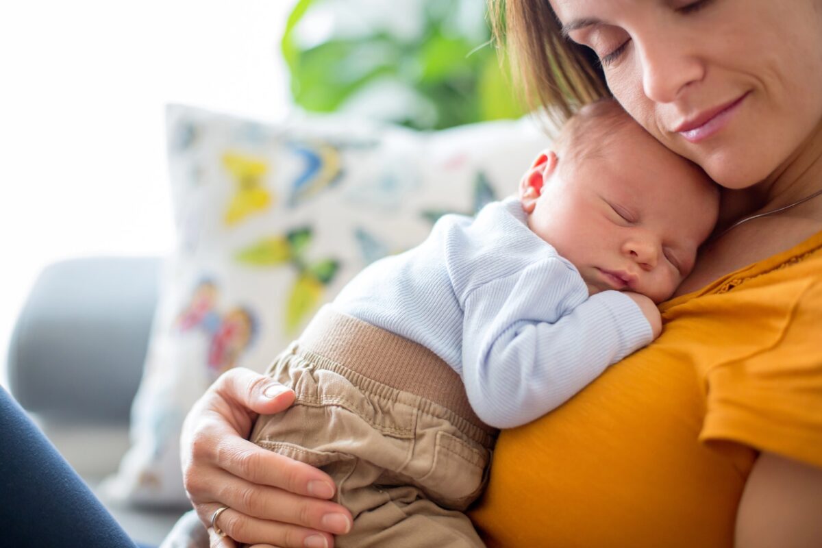 jeune maman caline son bébé endormi sur elle